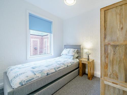 a small bedroom with a bed and a window at Kays in Cleveleys