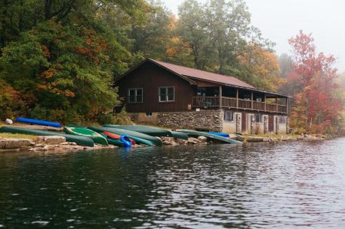 a group of kayaks lined up next to a building on a lake at Mohican Outdoor Center in Blairstown