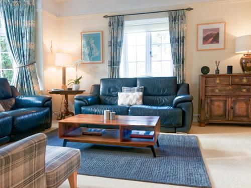 a living room with a blue couch and a coffee table at Granton Lodge in Far Sawrey