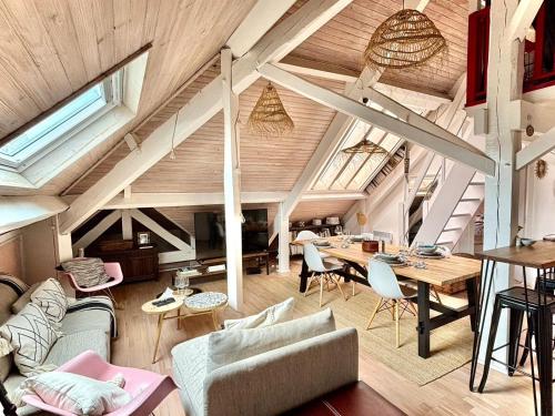 un salon mansardé avec une table et des chaises dans l'établissement Cosy loft by the ocean, à La Celle-sous-Gouzon