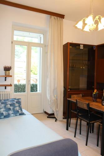 a bedroom with a bed and a table and a window at Angel's Como Lake Apartment in Como