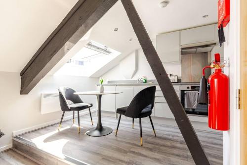 a room with a table and two chairs and a kitchen at 2-Bed Apartment with Sofa Bed, Sleeps up to 6, Perfect for Groups & Familie in Liverpool