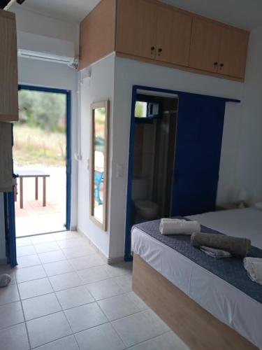 a bedroom with a bed and a door to a patio at Lendas Paradise studio 2 in Léntas
