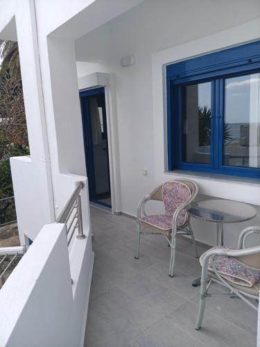 a patio with chairs and a table and a window at Lendas Paradise studio 2 in Léntas