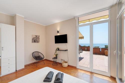 a living room with a tv and a sliding glass door at Casa Della Baia With a beautiful view in Varazze