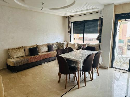 a living room with a couch and a table and chairs at Appartement vu sur mer in Pont Blondin