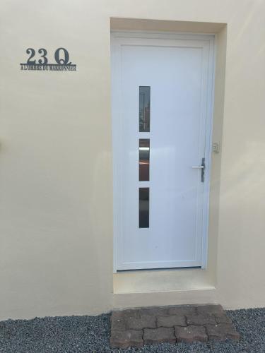 a white door with a sign on the side of a building at A l'ombre du Marronnier in Préfailles