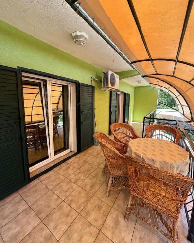 Un comedor con mesa y sillas en un patio. en Ninas Apartment, en Marovići