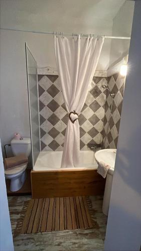 a bathroom with a shower with a tub and a toilet at Chambre Bohème chic avec jacuzzi in Liouc