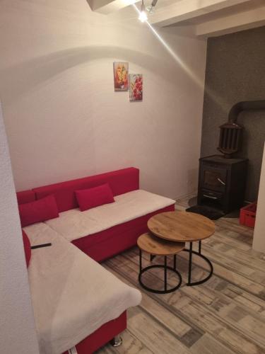 a living room with a red couch and a table at Vikendica Artos in Bihać