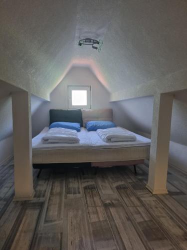 a bed with blue pillows in a room at Vikendica Artos in Bihać