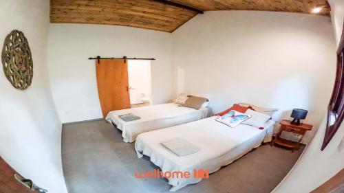a room with two beds and a window at Suíte em São Francisco Xavier ao Redor da Natureza in São Francisco Xavier