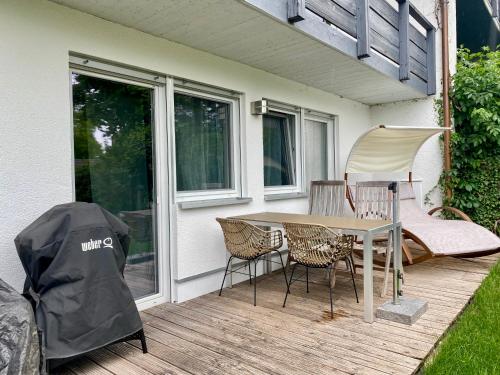 a patio with a table and chairs on a deck at 2 Zimmer Ferienwohnung mit Terrasse fußläufig zu S-Bahn nach München und See in Wörthsee