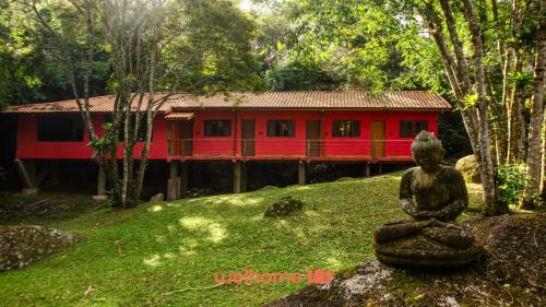 a small statue in front of a red house at Casa em Sao Francisco Xavier com Piscina in São José dos Campos