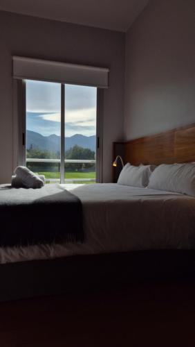 a bedroom with a large bed with a large window at Amalinas Hotel in San Lorenzo