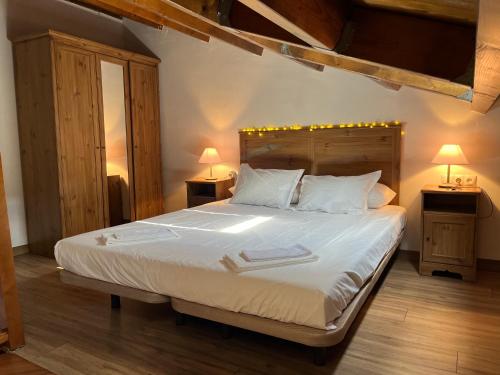 a bedroom with a large white bed with two lamps at La Caseta del Pont in Camprodon