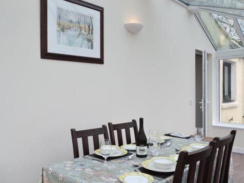 a dining room table with chairs and a bottle of wine at Isle View - 28284 in Broadford