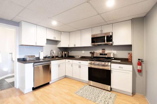 a kitchen with white cabinets and stainless steel appliances at Chain O' Lakes Beach Penthouse Sunset View and Boat Dock 