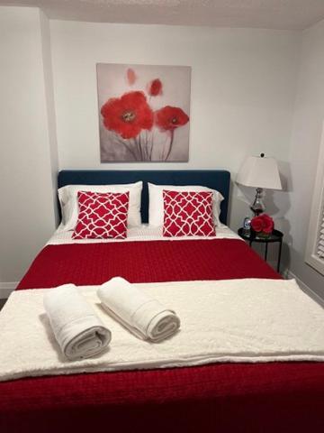 a bedroom with a red and white bed with pillows at Family-Friendly 4BR Retreat Fully Furnished in Sarnia