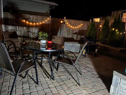 a table and chairs on a patio at night at Family-Friendly 4BR Retreat Fully Furnished in Sarnia