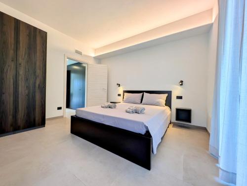 a bedroom with a large bed with white sheets at Appartamenti Ciliegio & Ulivo in Dongo