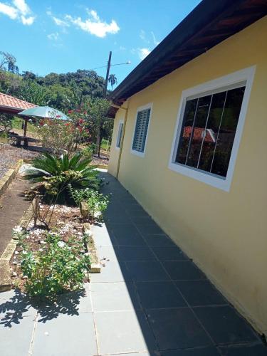 a sidewalk next to a house with a window at Pé na roça in Camanducaia