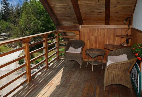 a porch with chairs and a table on a deck at Miškar Rooms in Cerknica