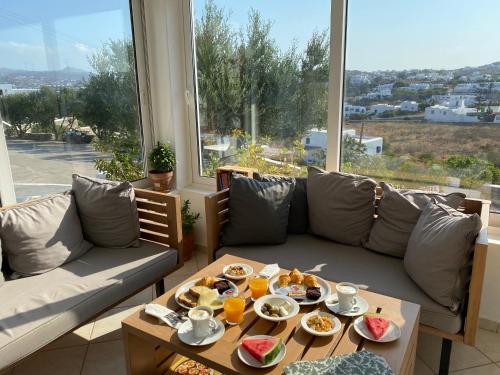 a living room with a couch and a table with food on it at Hotel Charissi in Mýkonos City
