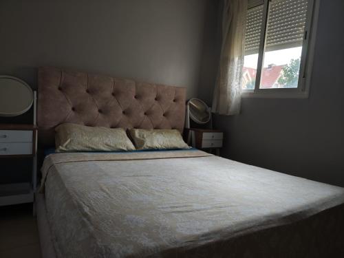 a bedroom with a large bed with a headboard and a window at Ifrane Home in Ifrane