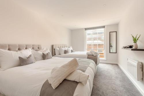 a white bedroom with two beds and a window at Spacious 2Bed Central Liverpool Nightlife & Events, sleeps up to 10 in Liverpool