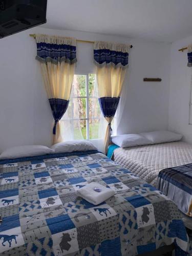 a bedroom with two beds and a window at Vista Farallones Hostel in Jardin