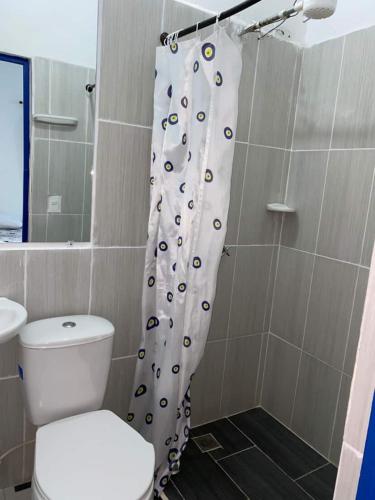 a bathroom with a toilet and a shower curtain at Vista Farallones Hostel in Jardin