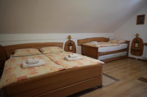a bedroom with two beds with towels on them at Miškar Rooms in Cerknica