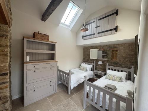 2 camas individuales en un dormitorio con ventana en Rawcliffe Barn, 2 Bedroom, up to 4 Guests, en Newton