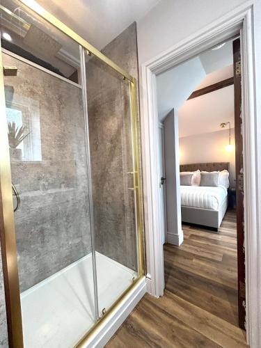 a glass shower in a room with a bedroom at Luxury Penarth Loft - Near Cardiff in Penarth
