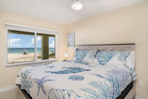 a bedroom with a bed with a view of the beach at Beach Front Villa - Right On The Beach! in Holmes Beach