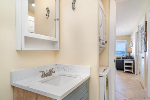 a kitchen with a white sink and a living room at Beach Front Villa - Right On The Beach! in Holmes Beach