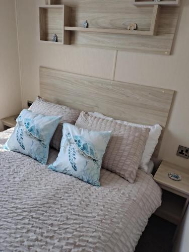 a bed with blue and white pillows on it at 3 bed Sleeps 8 Wifi and Linen inc in Corton
