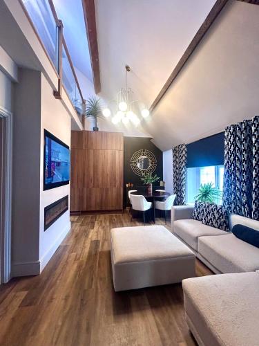 a living room with a couch and a tv at Luxury Penarth Loft - Near Cardiff in Penarth