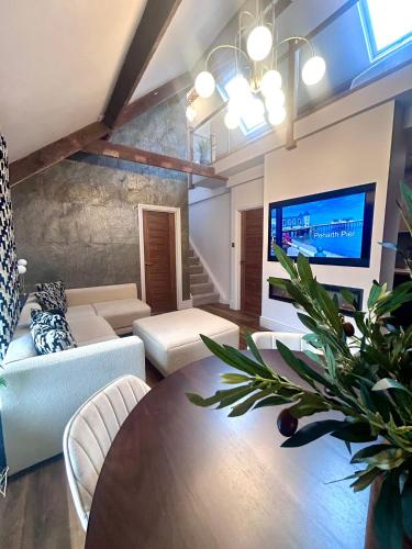 a living room with a couch and a table at Luxury Penarth Loft - Near Cardiff in Penarth
