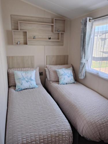 two beds in a small room with a window at 3 bed Sleeps 8 Wifi and Linen inc in Corton