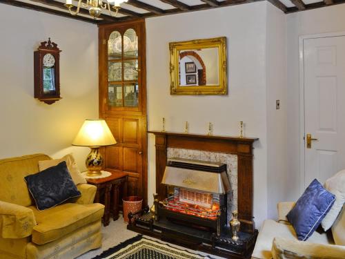 sala de estar con chimenea y espejo en Y Bwthyn, en Bala