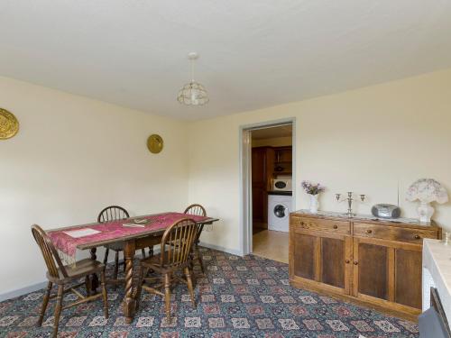 a kitchen with a dining room table and chairs at Bank Top Cottage in Hathersage