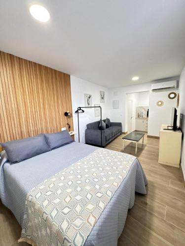 a bedroom with a large bed and a couch at Entrecallejones in Carmona