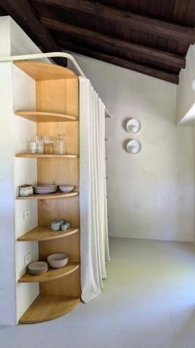 a room with wooden shelves with dishes on them at Cascina Le Moire in Merana