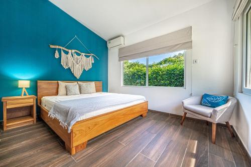 a bedroom with a bed and a window and a chair at Villarreal House in Tamarindo
