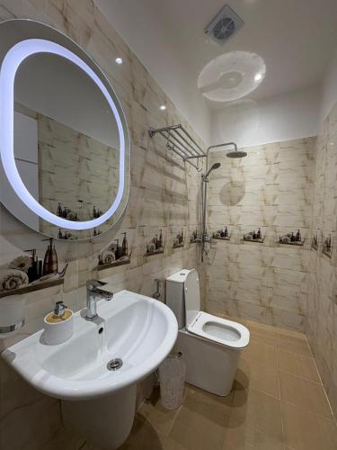 Un baño con lavabo, inodoro y espejo. en Luxury suite T2, Mamelle, Dakar, Sénégal, en Dakar