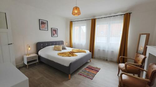 ein Schlafzimmer mit einem Bett und einem Stuhl in der Unterkunft Le Miel d'Opale - Ferry, Shuttle and Beach in Calais