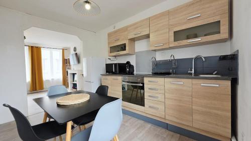 eine Küche mit einem Tisch und Stühlen in einer Küche in der Unterkunft Le Miel d'Opale - Ferry, Shuttle and Beach in Calais