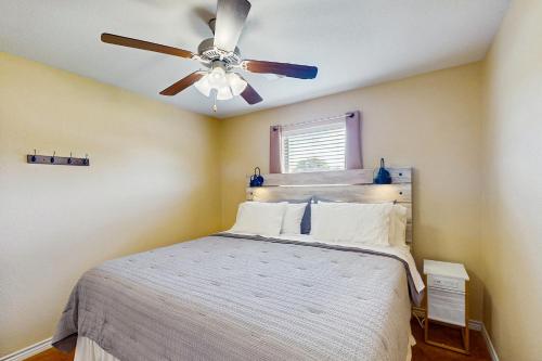 Un dormitorio con una cama con ventilador de techo. en Llano River Getaway, en Kingsland